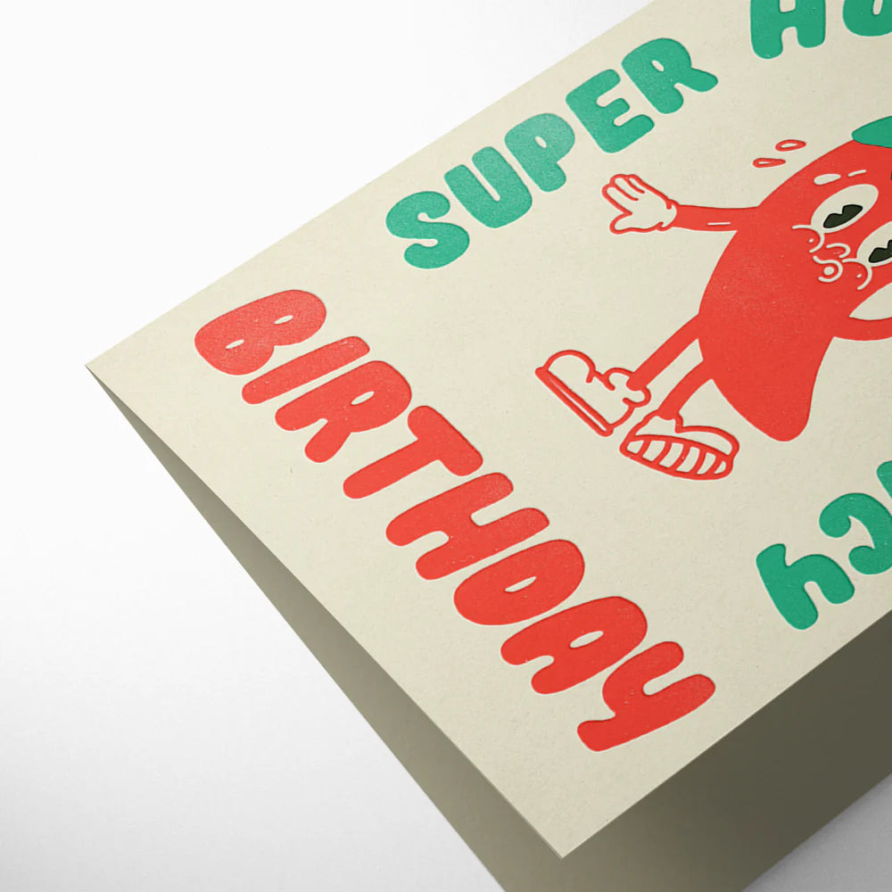 Birthday card with red and green text and a cartoon character on a beige background
