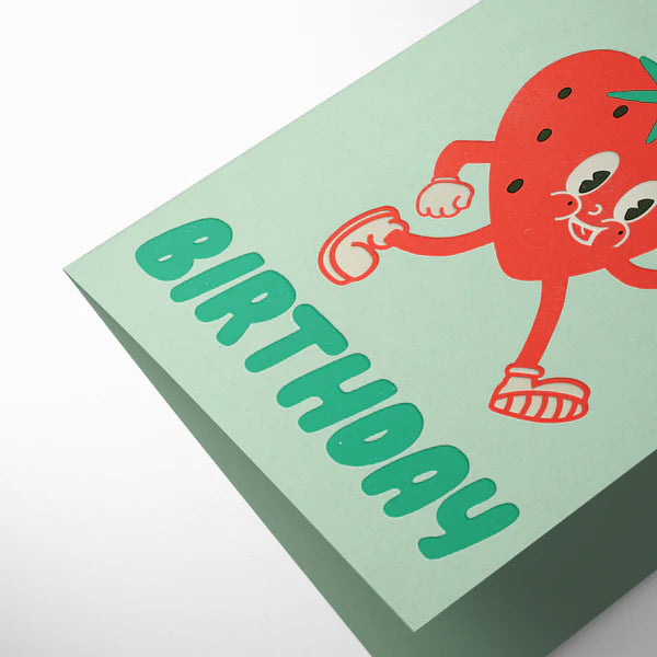 Green birthday card with a red cartoon character on a mint green background