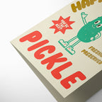 Pickle-themed product packaging with a cartoon pickle character on a beige background
