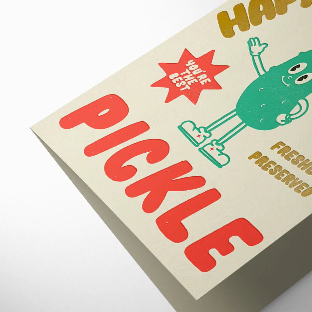 Pickle-themed product packaging with a cartoon pickle character on a beige background