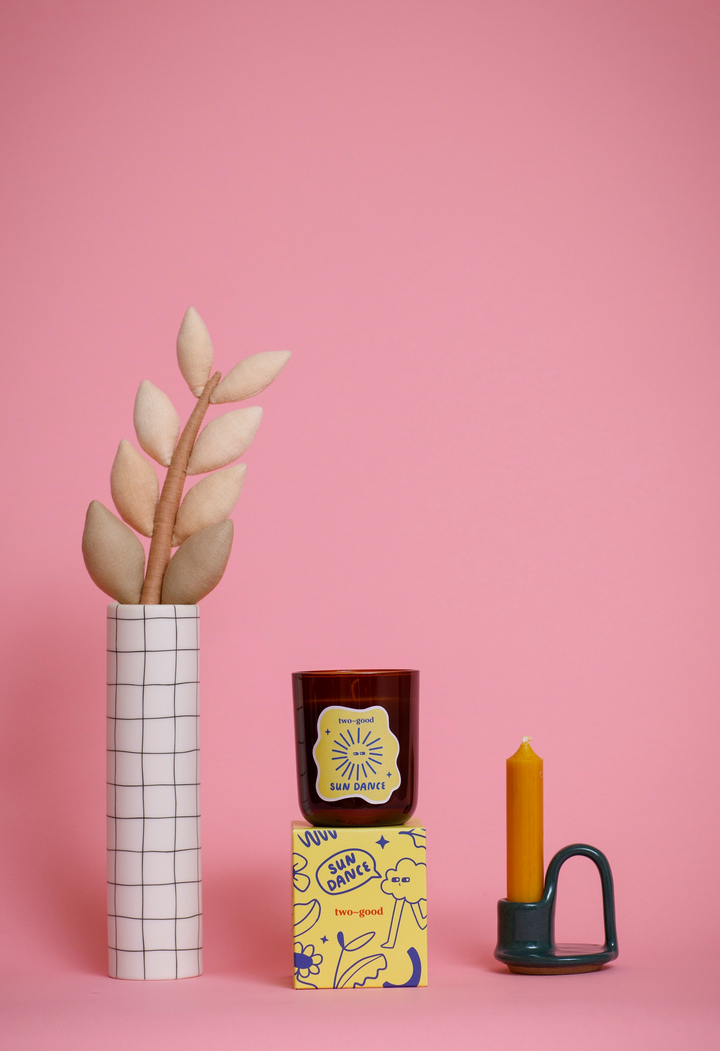 Decorative items including a vase with plant, a candle, and a box on a pink background. Coconut scent.
