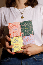 Person holding a colourful candle boxes with various designs on the cover. Illustrations with bold designs. 