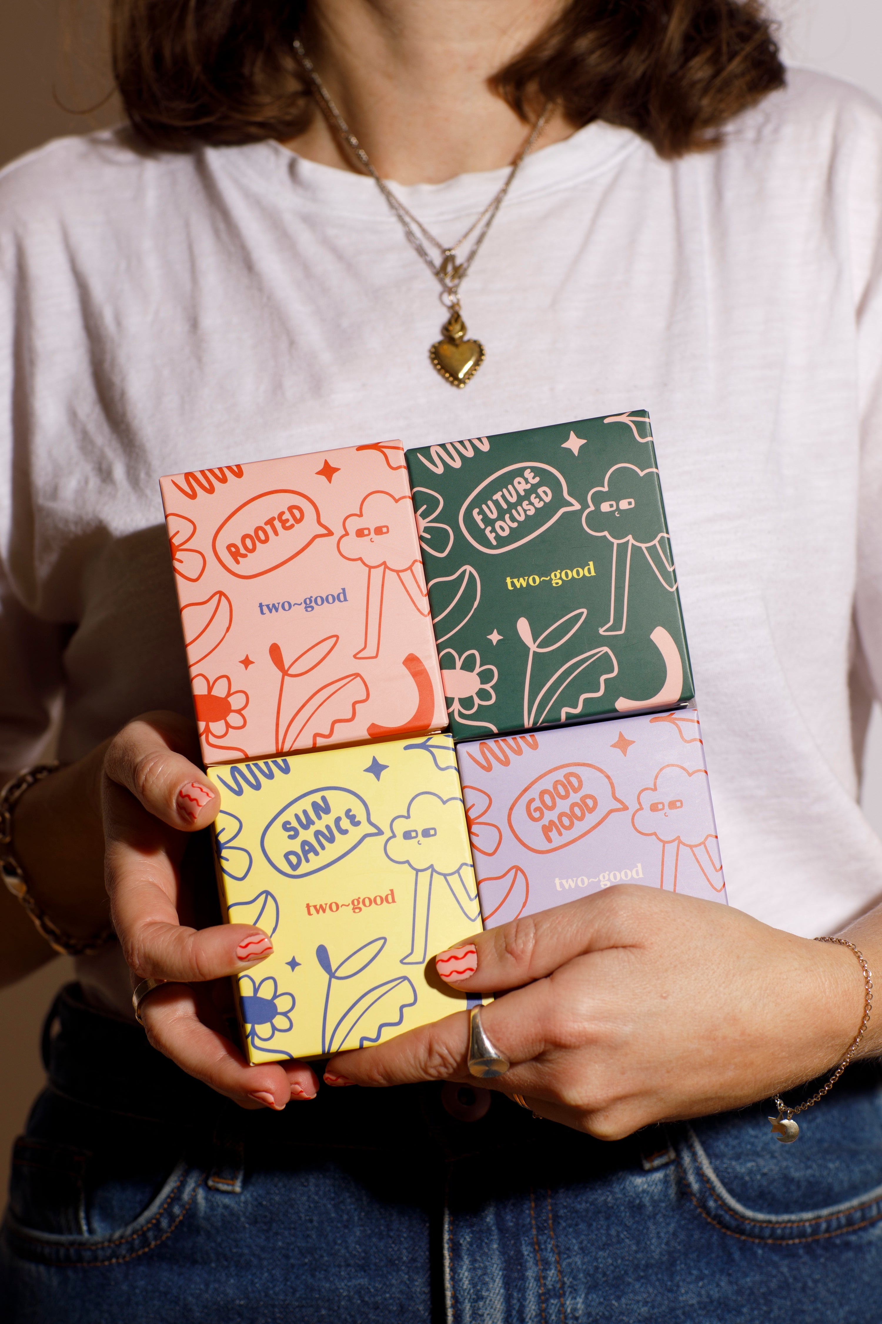 Person holding a colourful candle boxes with various designs on the cover. Illustrations with bold designs. 